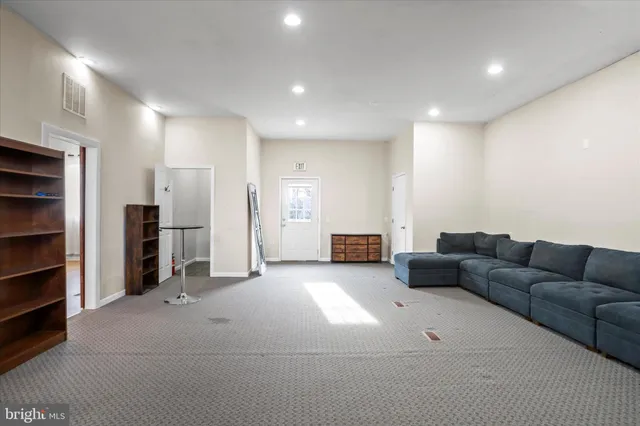 a living room with furniture and kitchen view