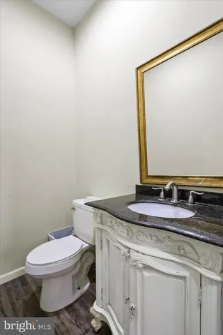 a bathroom with a granite countertop toilet and a sink