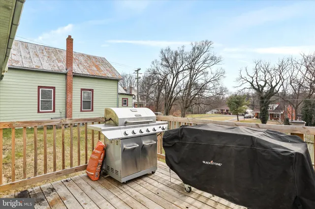 a view of a patio with wooden floor and iron fence