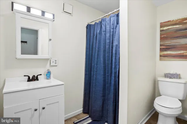 a bathroom with a toilet a sink a vanity and mirror