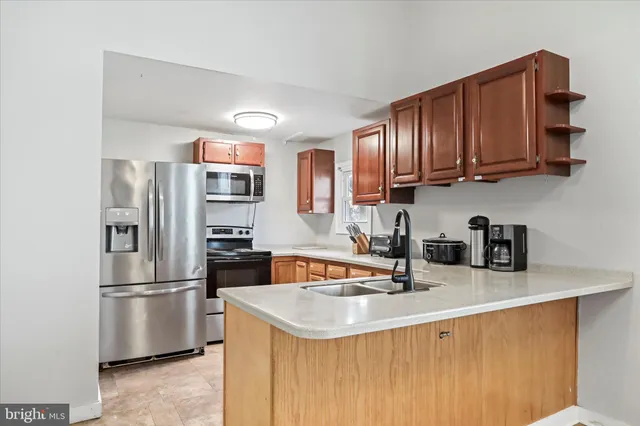 a kitchen with stainless steel appliances granite countertop a refrigerator a sink a stove and oven