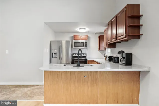 a kitchen with stainless steel appliances granite countertop a sink a stove and a refrigerator