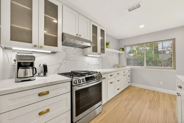 a kitchen with kitchen island a counter top space a refrigerator and a sink