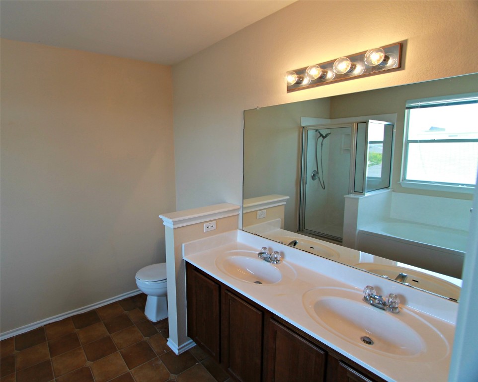 213 Banner Avenue Leander, TX 78641 - Photo 14 of 22 Bathroom with a bath, double vanity, and a stall shower
