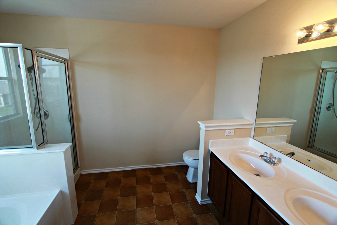 213 Banner Avenue Leander, TX 78641 - Photo 15 of 22 Full bath featuring a shower stall, double vanity, and a bath