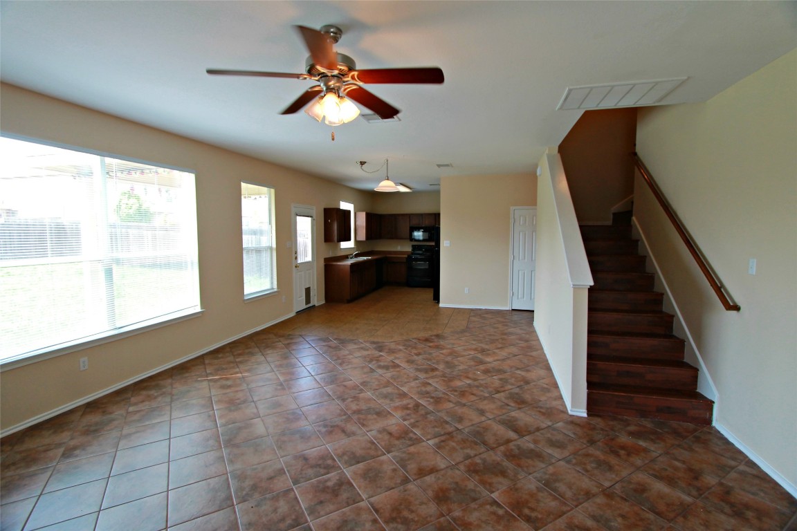213 Banner Avenue Leander, TX 78641 - Photo 3 of 22 Unfurnished living room with stairs, dark tile patterned flooring, and ceiling fan