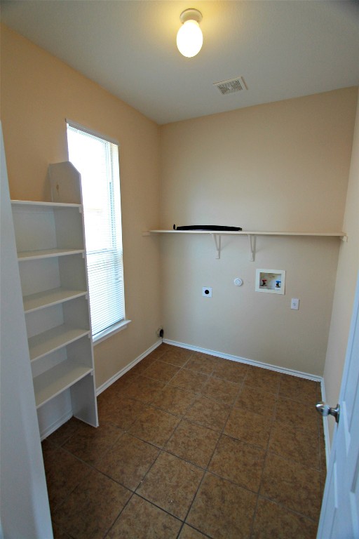 213 Banner Avenue Leander, TX 78641 - Photo 6 of 22 Laundry room featuring washer hookup, hookup for an electric dryer, and dark tile patterned flooring