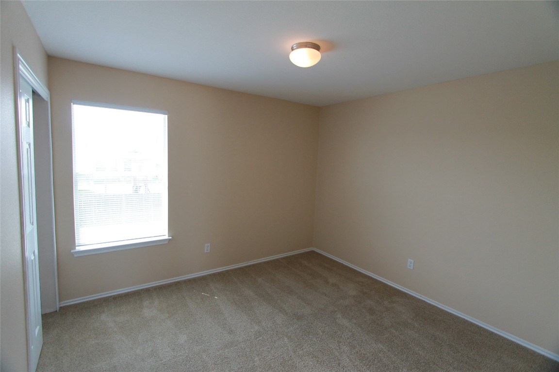 213 Banner Avenue Leander, TX 78641 - Photo 8 of 22 Empty room with light colored carpet and baseboards