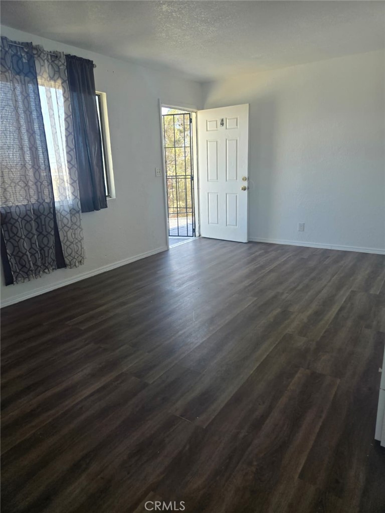 15879 Edwin Street Mojave, CA 93501 - Photo 3 of 12 an empty room with wooden floor and windows