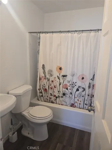 a white toilet sitting next to a shower curtain
