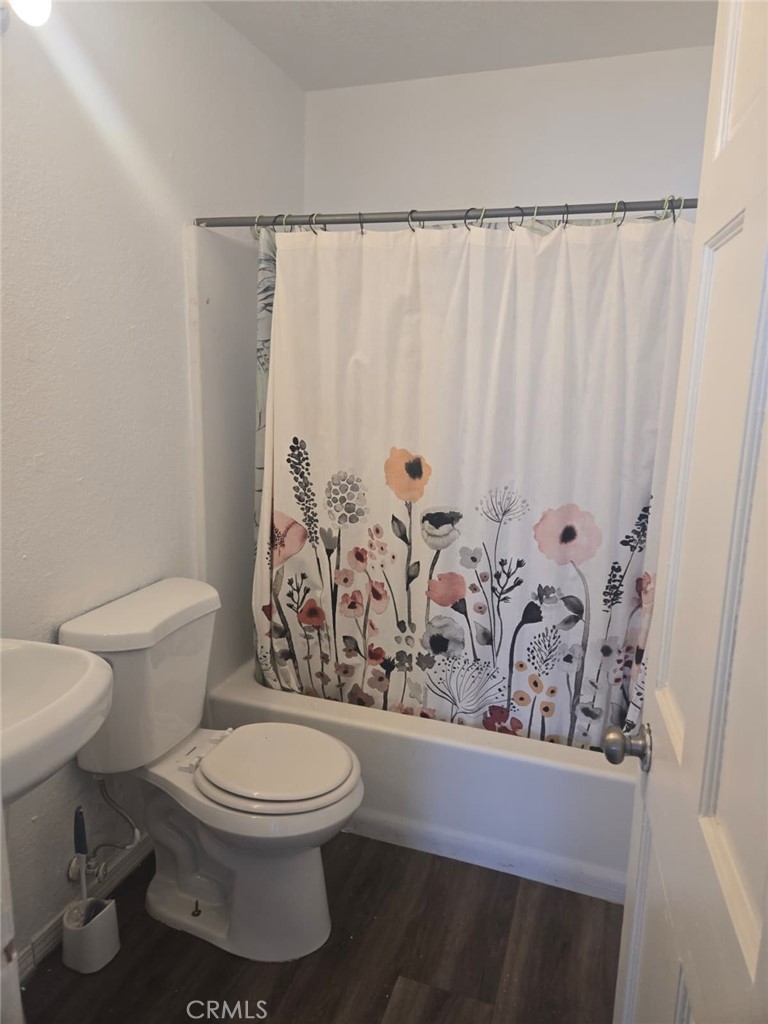 15879 Edwin Street Mojave, CA 93501 - Photo 5 of 12 a white toilet sitting next to a shower curtain
