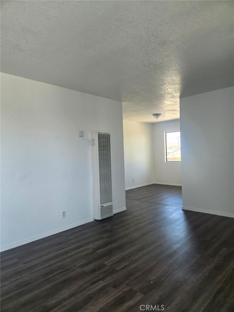15879 Edwin Street Mojave, CA 93501 - Photo 8 of 12 an empty room with wooden floor and windows
