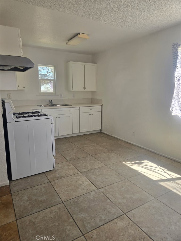 15879 Edwin Street Mojave, CA 93501 - Photo 9 of 12 a kitchen with stainless steel appliances a sink stove and cabinets