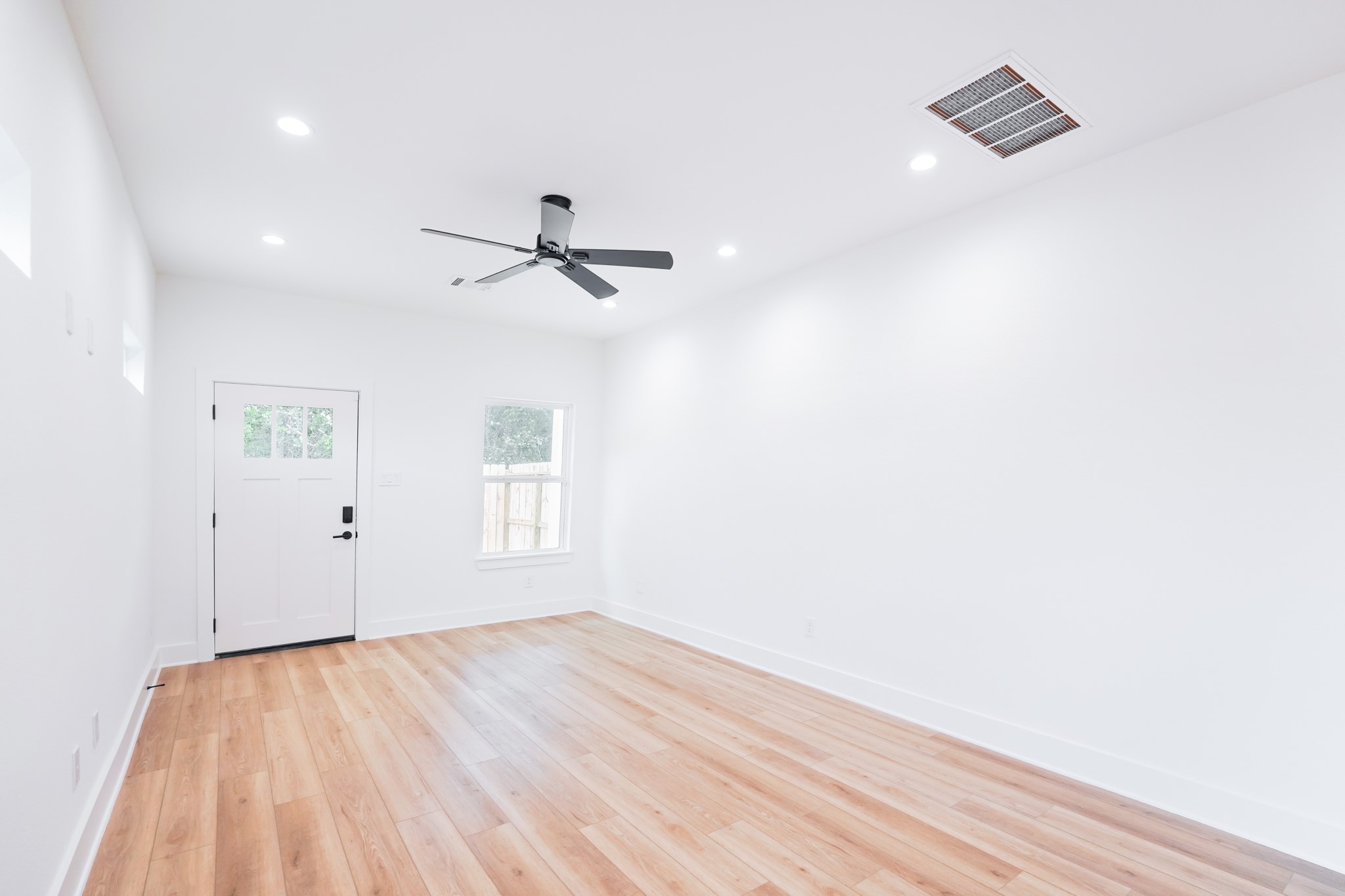 7903 Sunnyhill Street Houston, TX 77088 - Photo 13 of 33 a view of a room with wooden floor and white walls