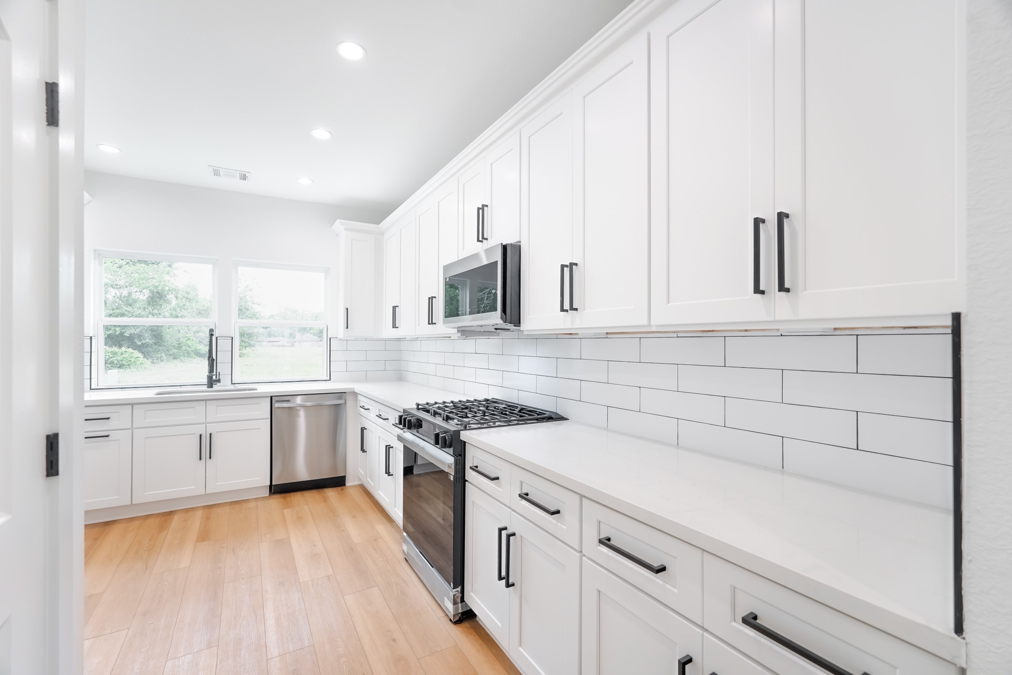 7903 Sunnyhill Street Houston, TX 77088 - Photo 6 of 33 a kitchen with granite countertop white cabinets and white appliances