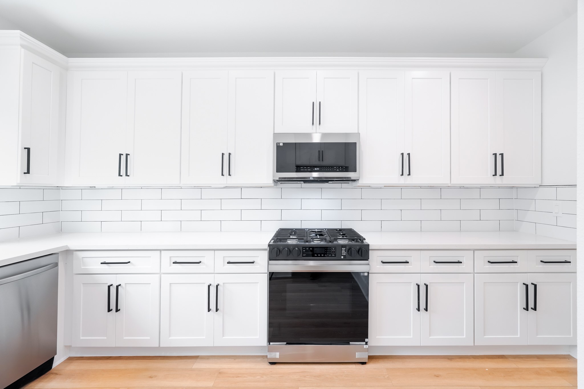 7903 Sunnyhill Street Houston, TX 77088 - Photo 8 of 33 a kitchen with white cabinets and appliances