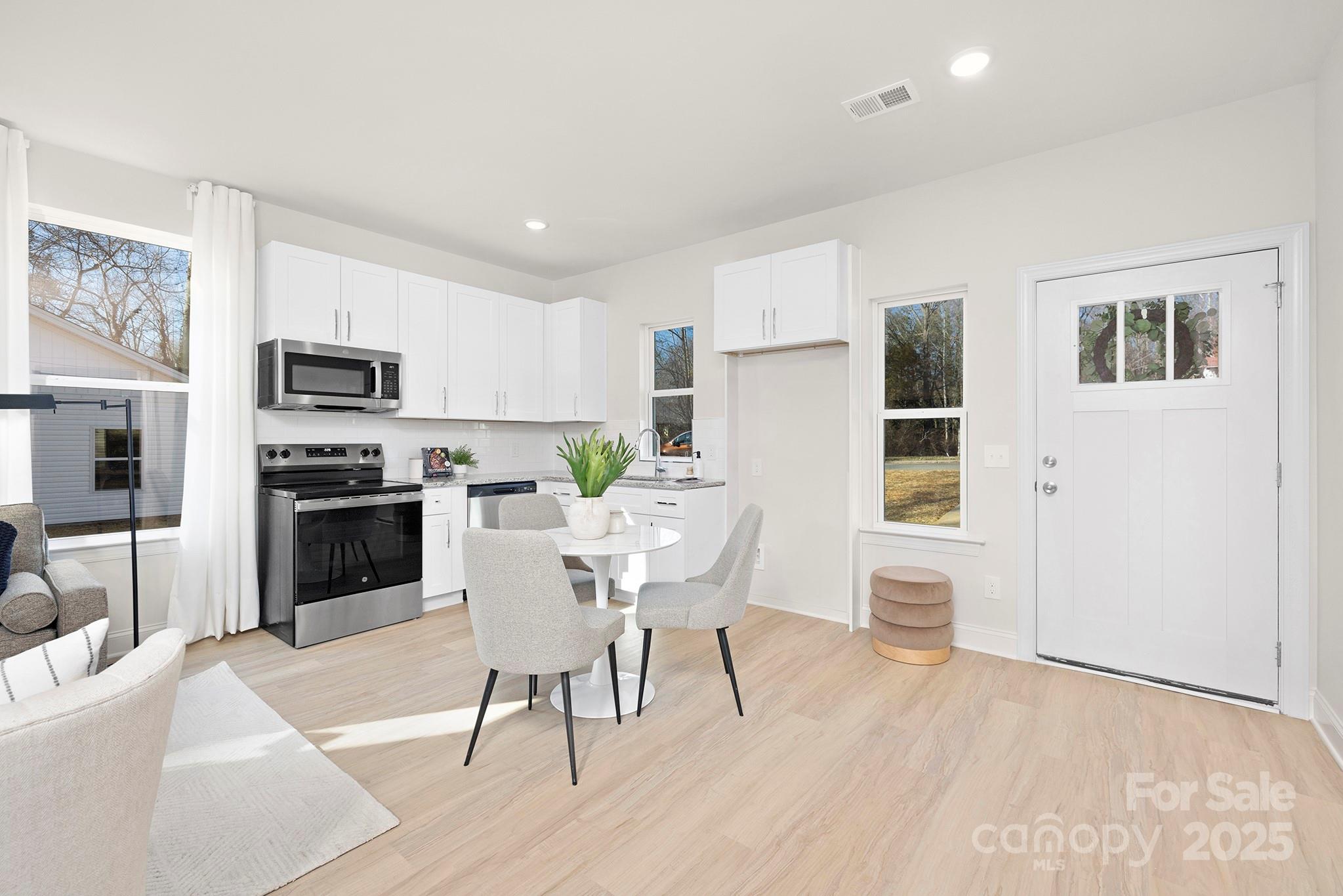 1124 Butler Street Salisbury, NC 28144 - Photo 10 of 19 a kitchen with stainless steel appliances a stove a sink dishwasher a refrigerator white cabinets and wooden floor