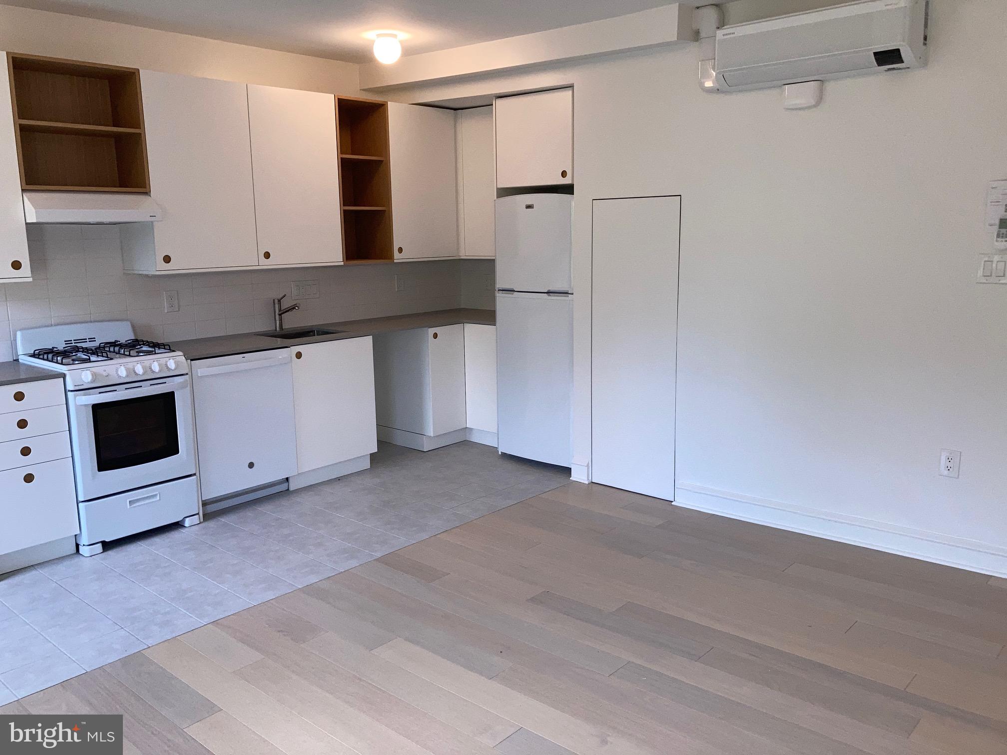 1108 Pine Street, Unit 3F Philadelphia, PA 19107 - Photo 3 of 10 a kitchen with stainless steel appliances white cabinets and a refrigerator