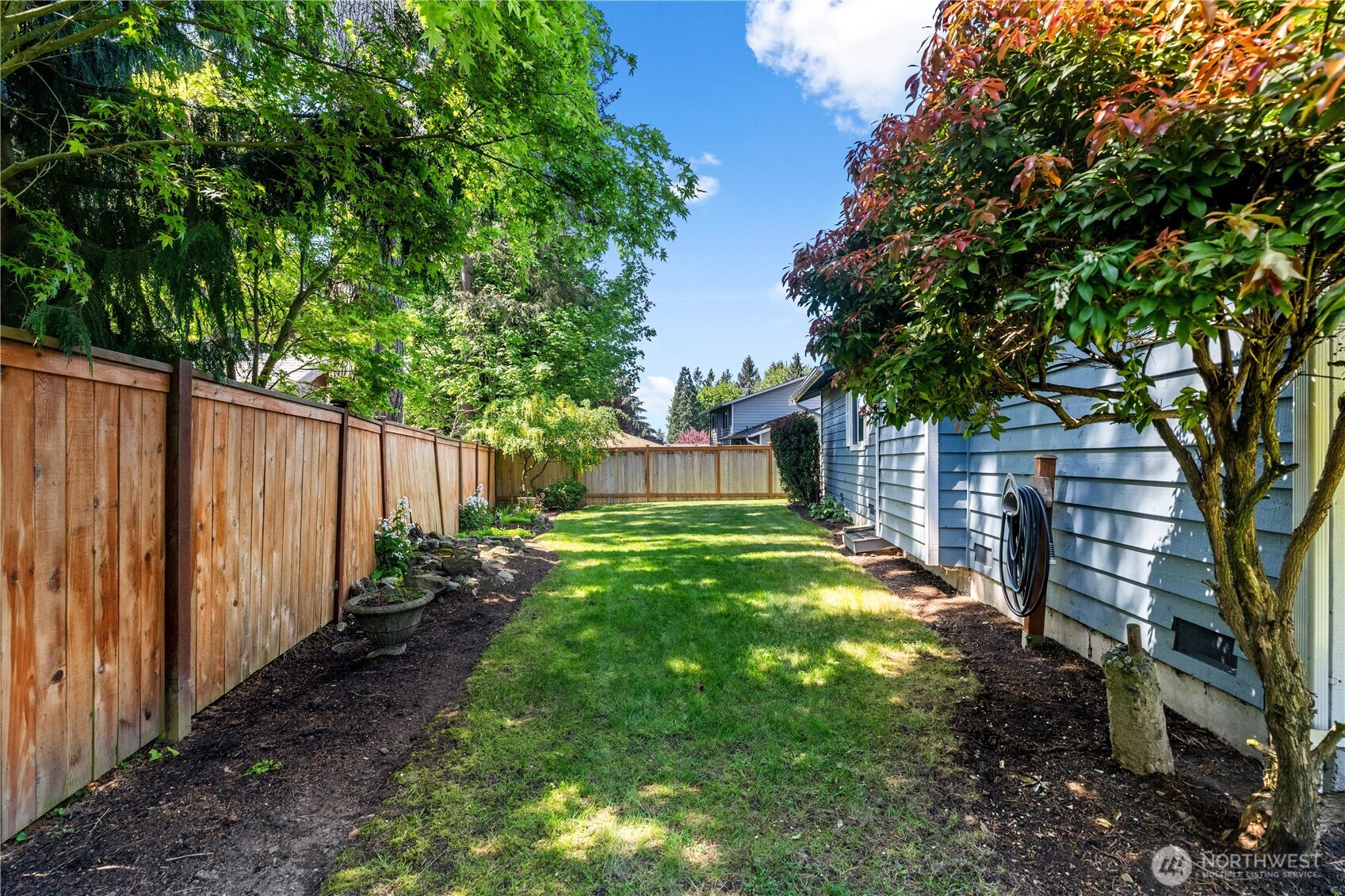 518 Hubbard Road Lynnwood, WA 98036 - Photo 32 of 39 a view of a backyard with large trees and wooden fence