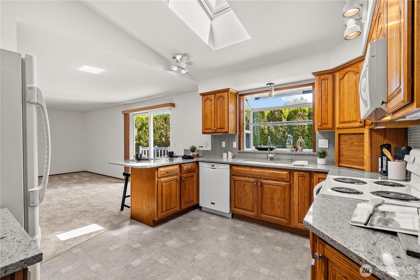 518 Hubbard Road Lynnwood, WA 98036 - Photo 8 of 39 a large kitchen with stainless steel appliances granite countertop a stove a sink and a refrigerator