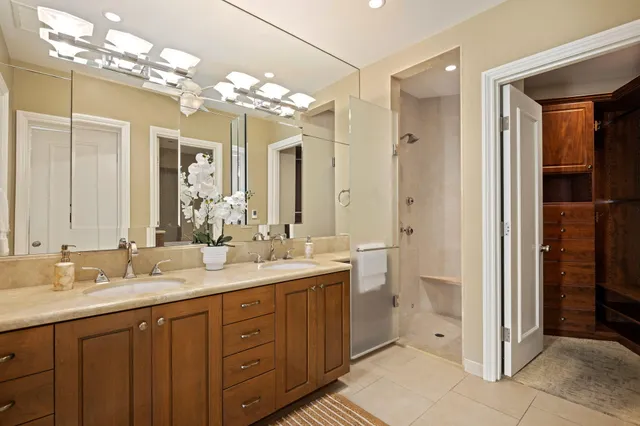 a spacious bathroom with a double vanity sink mirror and a shower