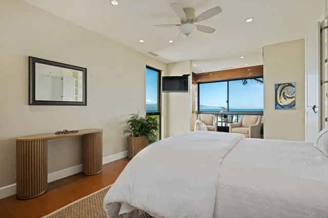 a large bedroom with a large bed and a chandelier