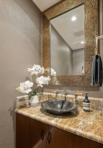 a bathroom with a granite countertop sink and a mirror