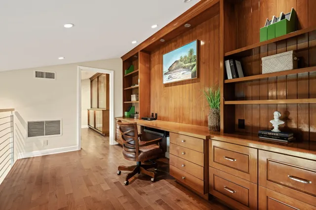 a view of a workspace with furniture and a window