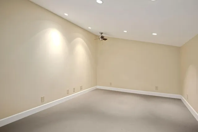 an empty room with a ceiling fan and a window