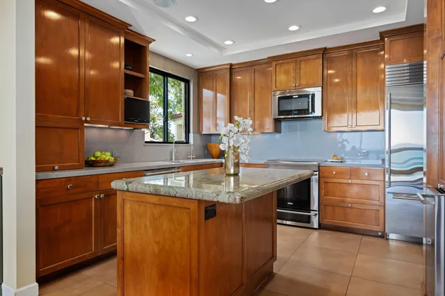 a kitchen with stainless steel appliances granite countertop a sink counter space cabinets and a large window