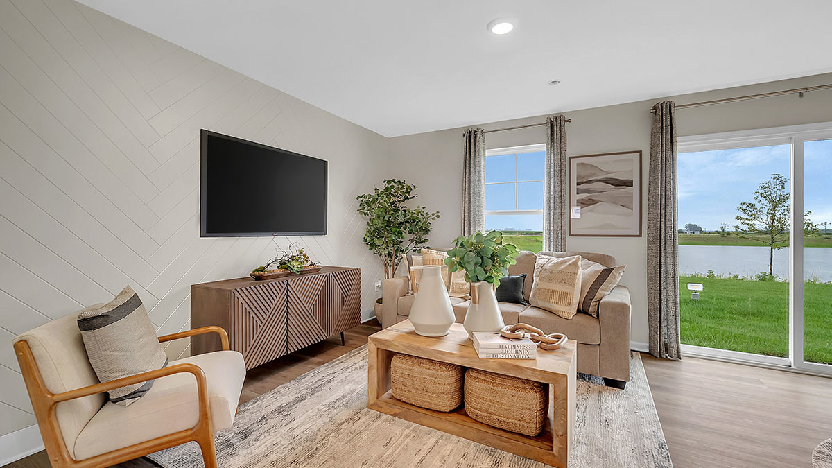 1811 Overland Drive Plainfield, IL 60586 - Photo 33 of 39 a living room with furniture a flat screen tv and a floor to ceiling window