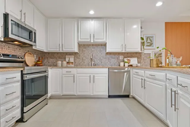 a kitchen with white cabinets stainless steel appliances and sink