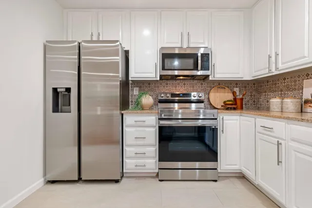 a kitchen with stainless steel appliances a stove a microwave and refrigerator