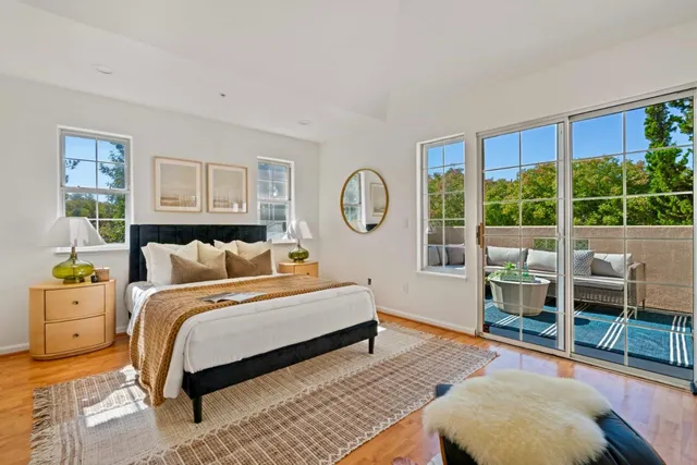 a spacious bedroom with a bed a table and a large window