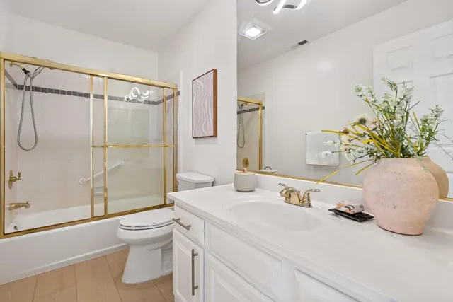 a view of a back yard with potted plants and large tree