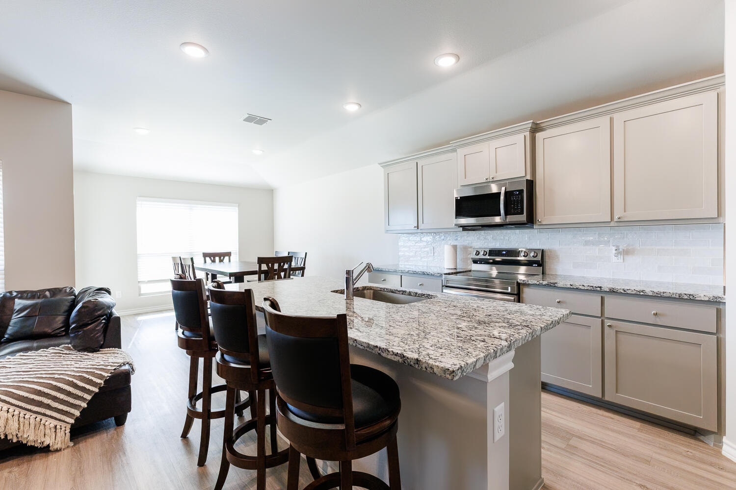 7205 25th Street Lubbock, TX 79407 - Photo 14 of 50 a kitchen with a table chairs microwave and cabinets