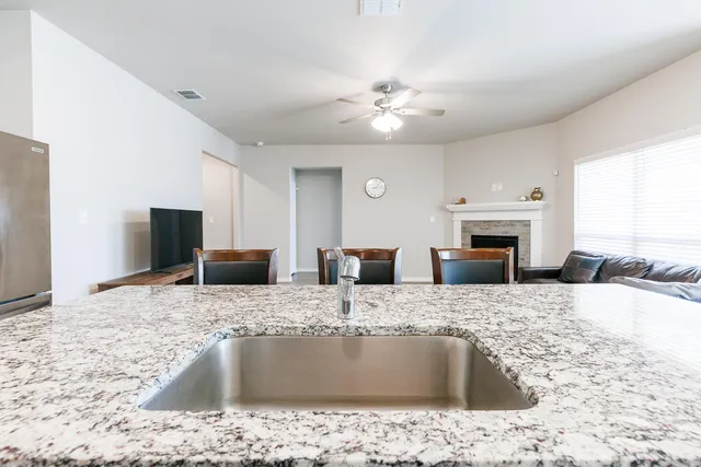 a kitchen with kitchen island granite countertop a sink a counter top space and appliances