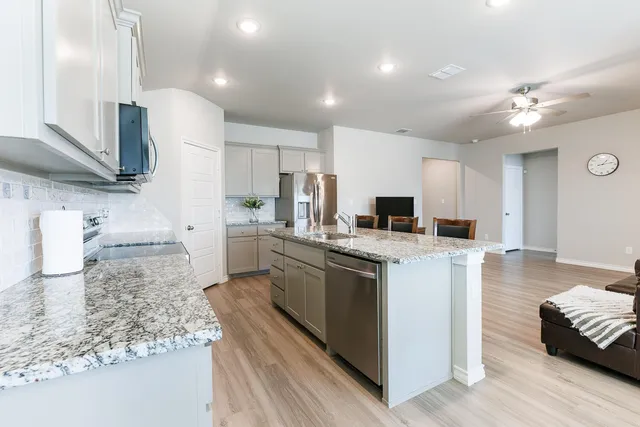 a kitchen with stainless steel appliances granite countertop a sink stove and refrigerator