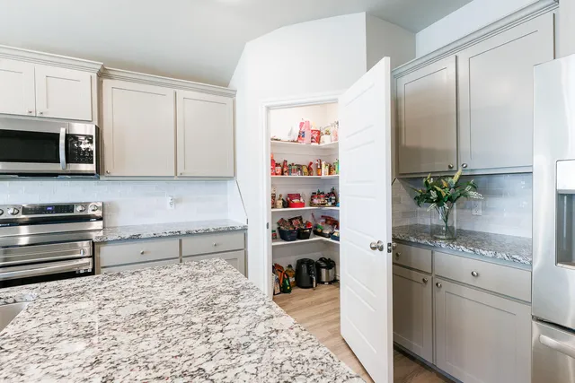a kitchen with a refrigerator and a stove top oven