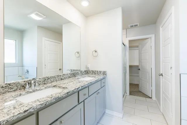 a bathroom with a granite countertop sink and a mirror