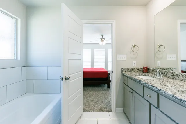 a bathroom with a tub sink and mirror