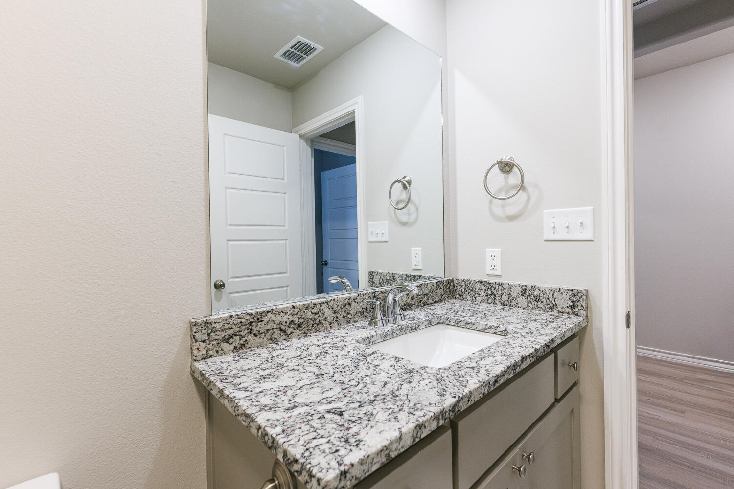 7205 25th Street Lubbock, TX 79407 - Photo 39 of 50 a bathroom with a granite countertop sink and a mirror