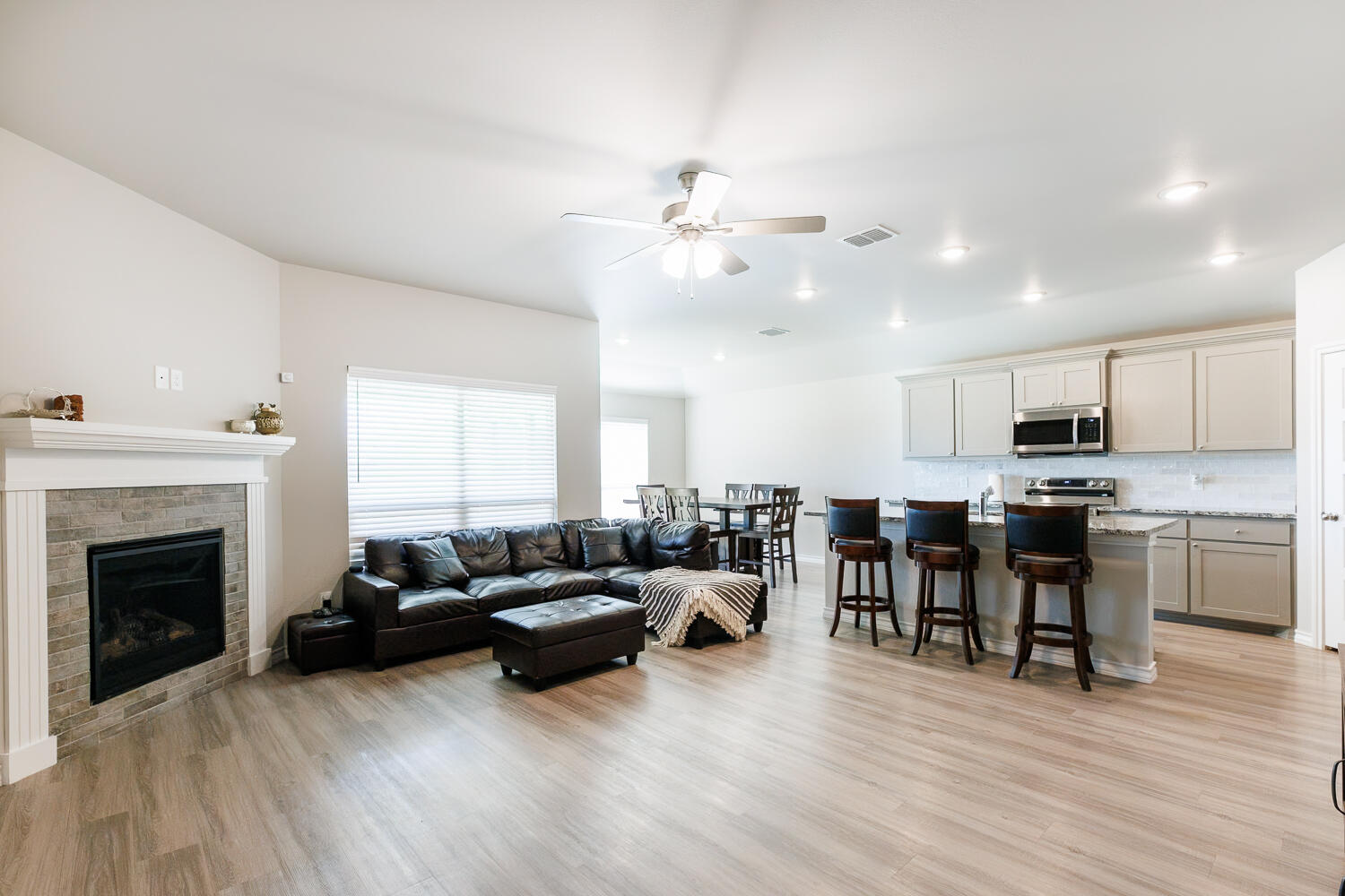 7205 25th Street Lubbock, TX 79407 - Photo 5 of 50 a living room with furniture kitchen view and a fireplace