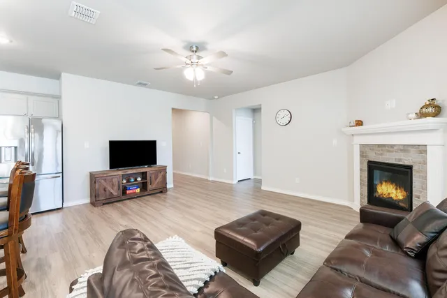 a living room with furniture a flat screen tv and a fireplace