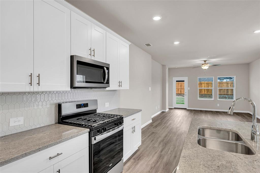 417 Martell Road Lowry Crossing, TX 75069 - Photo 11 of 29 a kitchen with stainless steel appliances granite countertop a sink stove and microwave