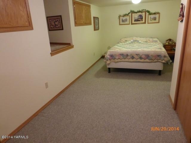 1640 Division Road Zillah, WA 98953 - Photo 20 of 49 a spacious bedroom with a bed and wall painting