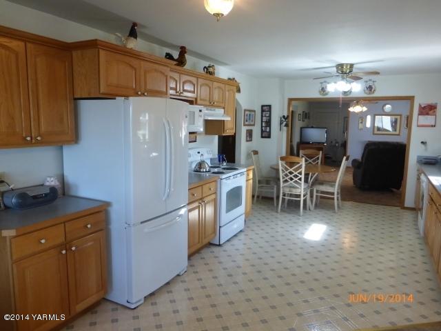 1640 Division Road Zillah, WA 98953 - Photo 8 of 49 a kitchen with granite countertop cabinets and refrigerator