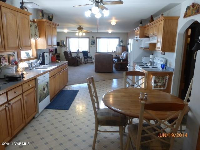 1640 Division Road Zillah, WA 98953 - Photo 10 of 49 a kitchen with stainless steel appliances kitchen island granite countertop a sink a stove a dining table and chairs