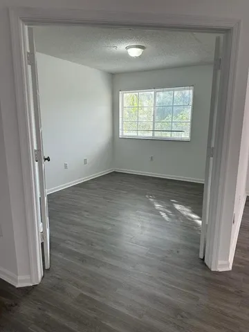 an empty room with wooden floor and closet