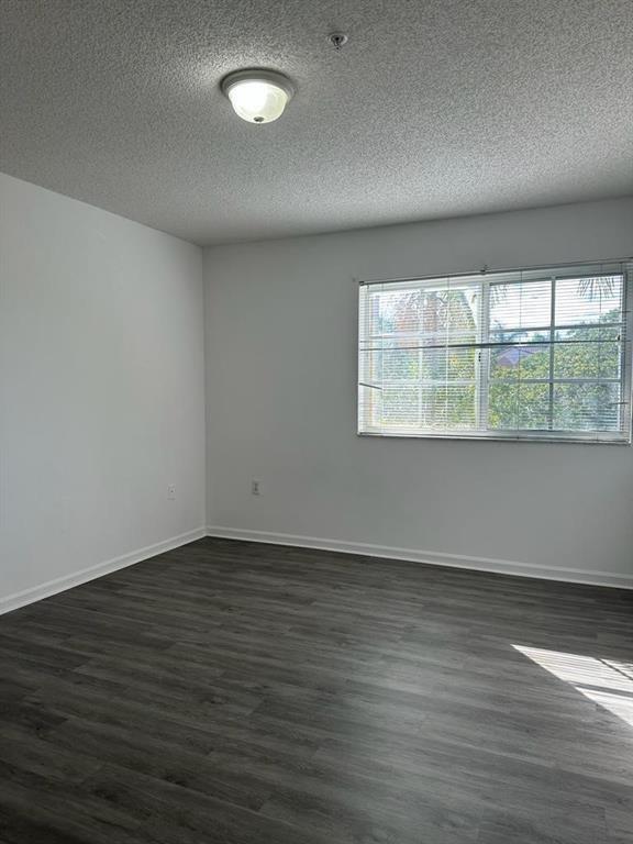 4844 North State Road 7, Unit 305 Pompano Beach, FL 33067 - Photo 17 of 23 a view of an empty room with wooden floor and a window
